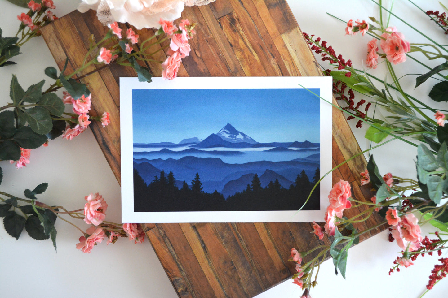 Landscape art print with illustration of a mountain range in varying shades of blue.