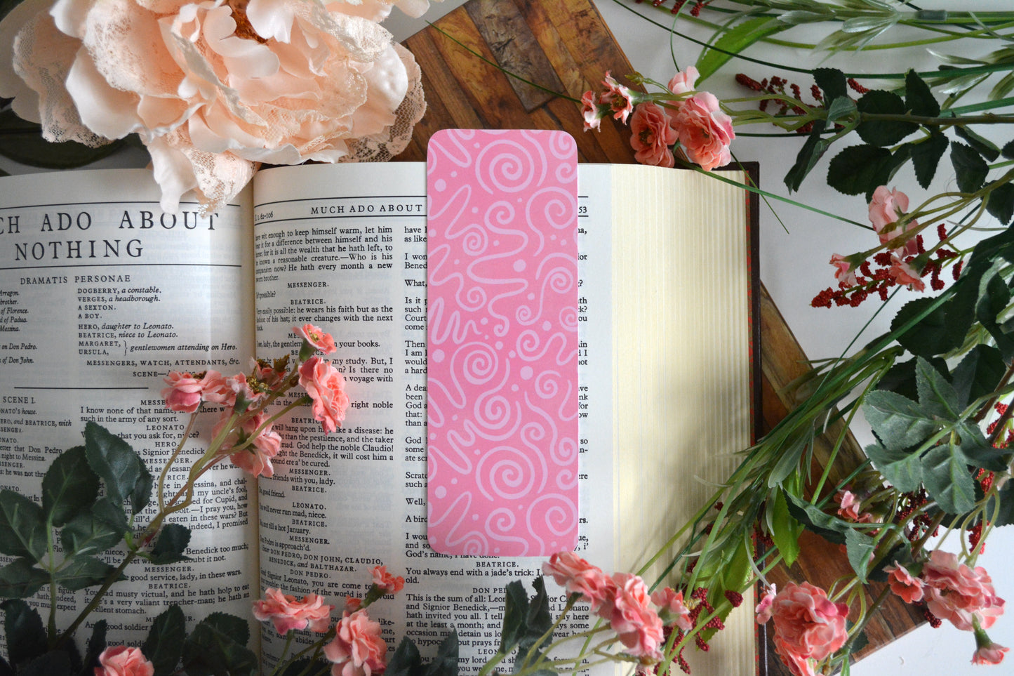 Bookmark with light pink icing drizzle swirls on a pink background.