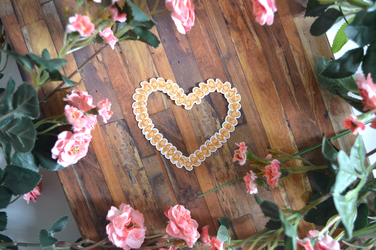 Individual sticker of a puakenikeni lei in the shape of a heart.
