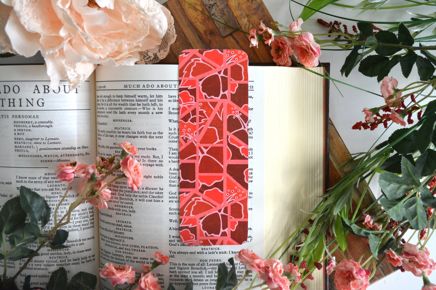 Bookmark with illustrations of mosaic tiles of hibiscus in varying shades of red.