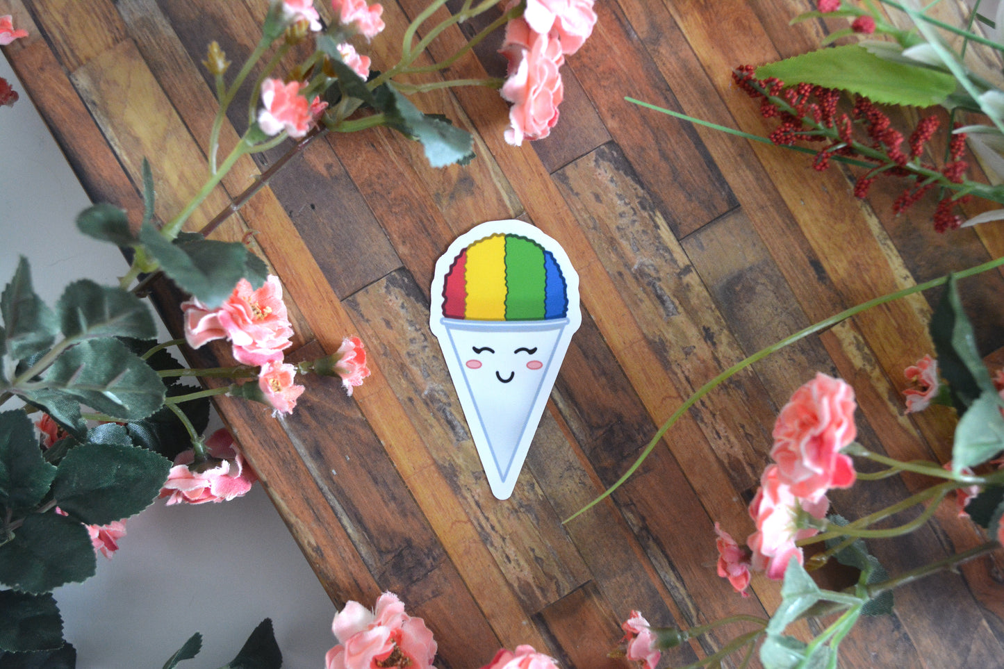 Individual sticker of a rainbow shave (shaved) ice illustration with a cute kawaii facial expression.