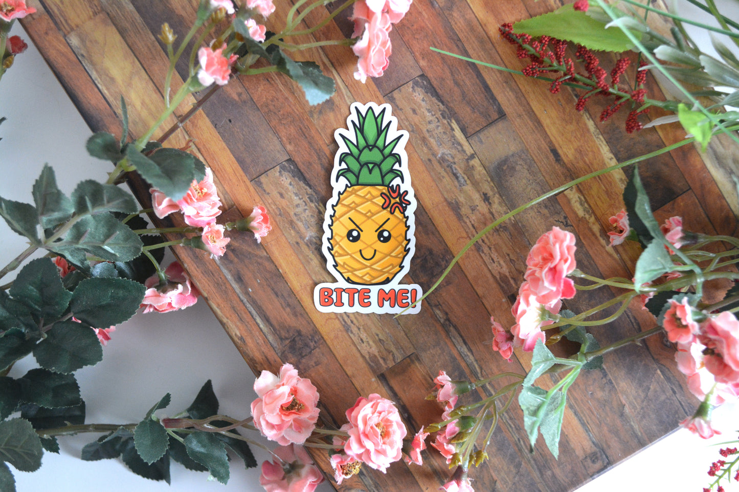 Individual sticker of a cute and sassy pineapple illustration with text reading "Bite Me!"