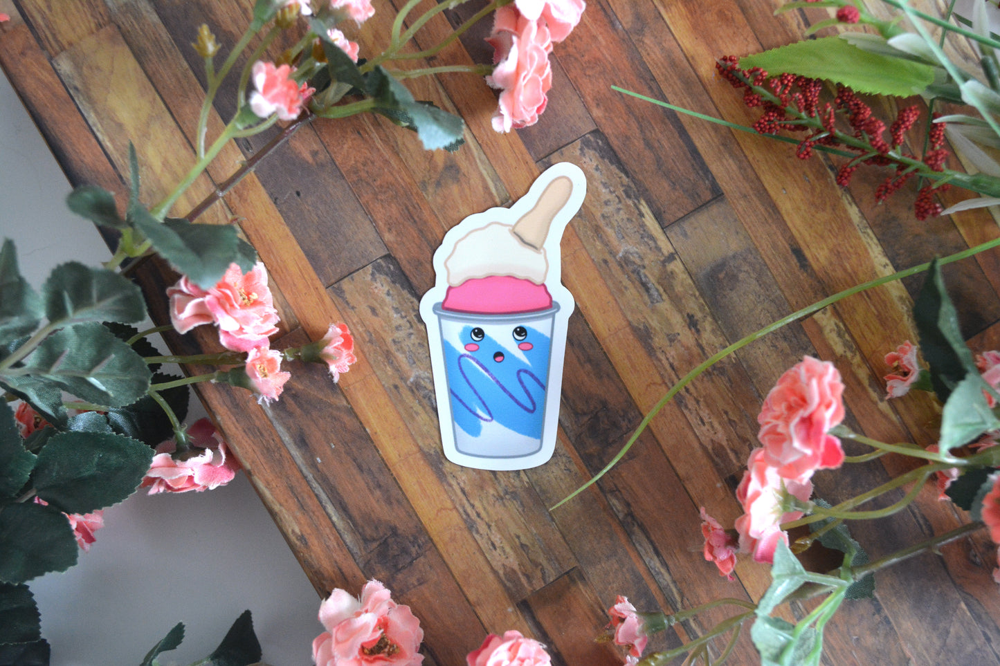 Individual sticker of a guri guri (ice cream) treat with a spoon sticking out of the top and a cute kawaii surprised facial expression.