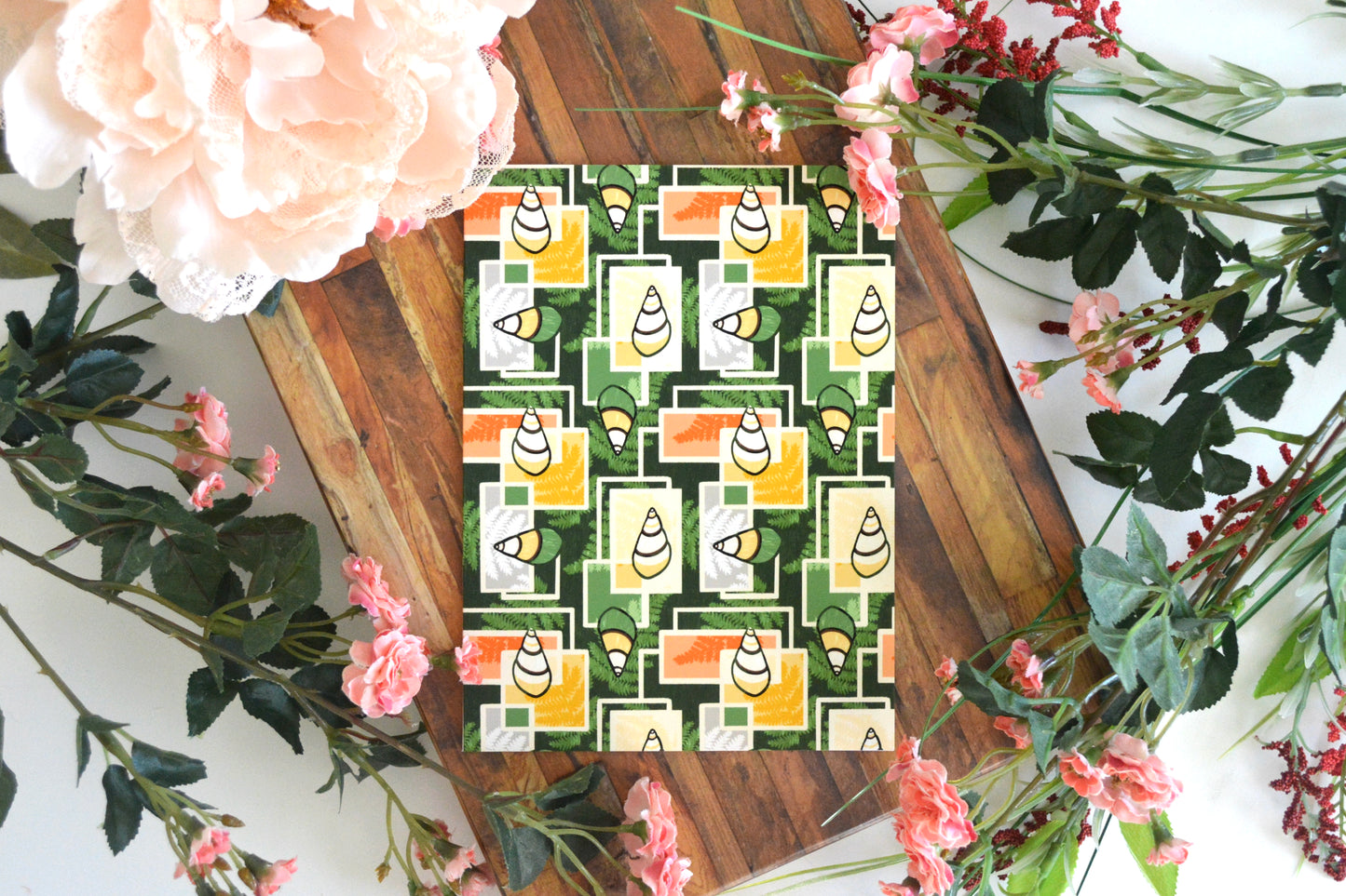 Greeting card with yellow, orange, and green kahuli (Hawaiian land snail) and fern geometric design on front.