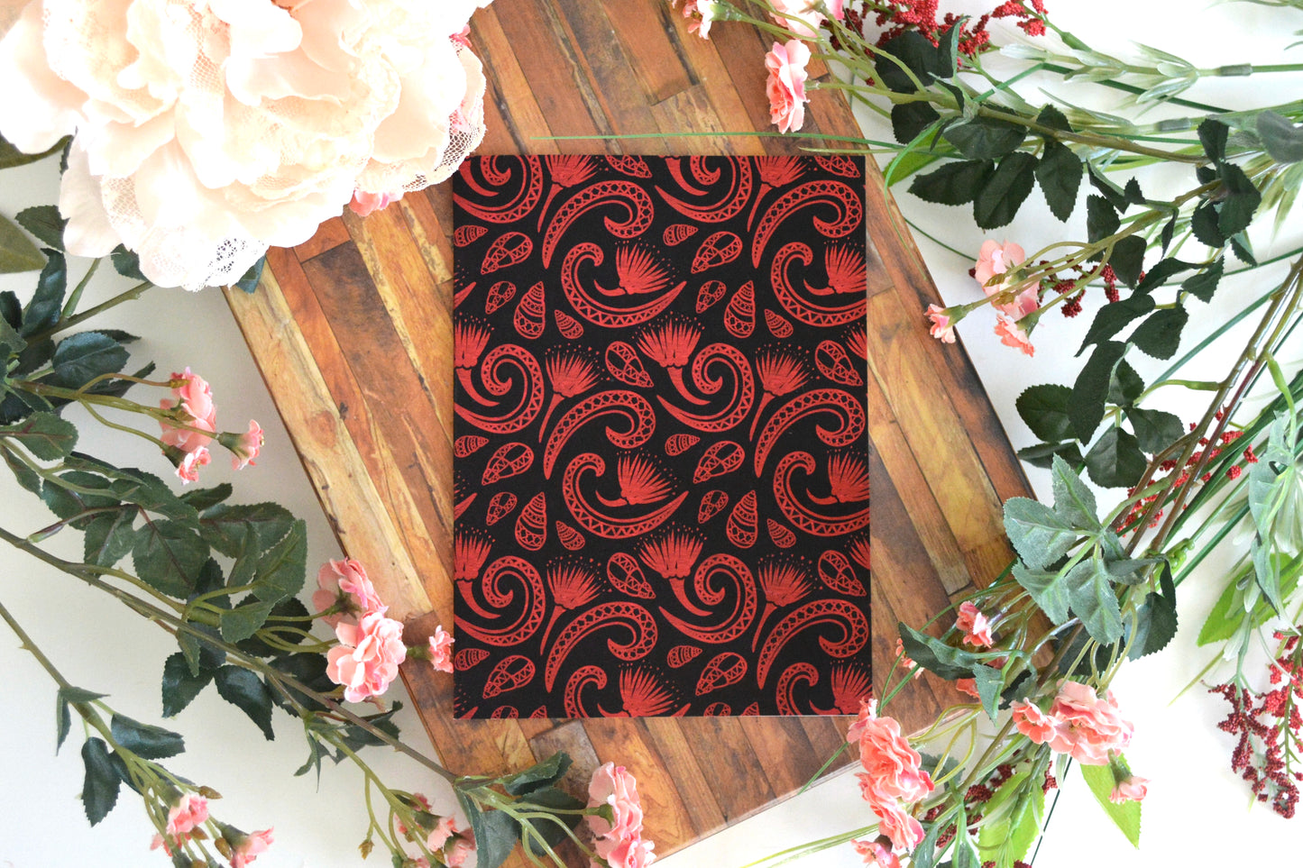 Greeting card with red kahuli (Hawaiian land snail) and ohia lehua design on cover.
