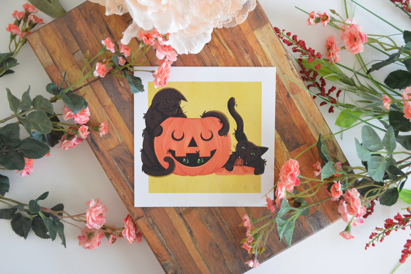 Halloween art print with illustration of three black cats playing in and around a jack-o-lantern.