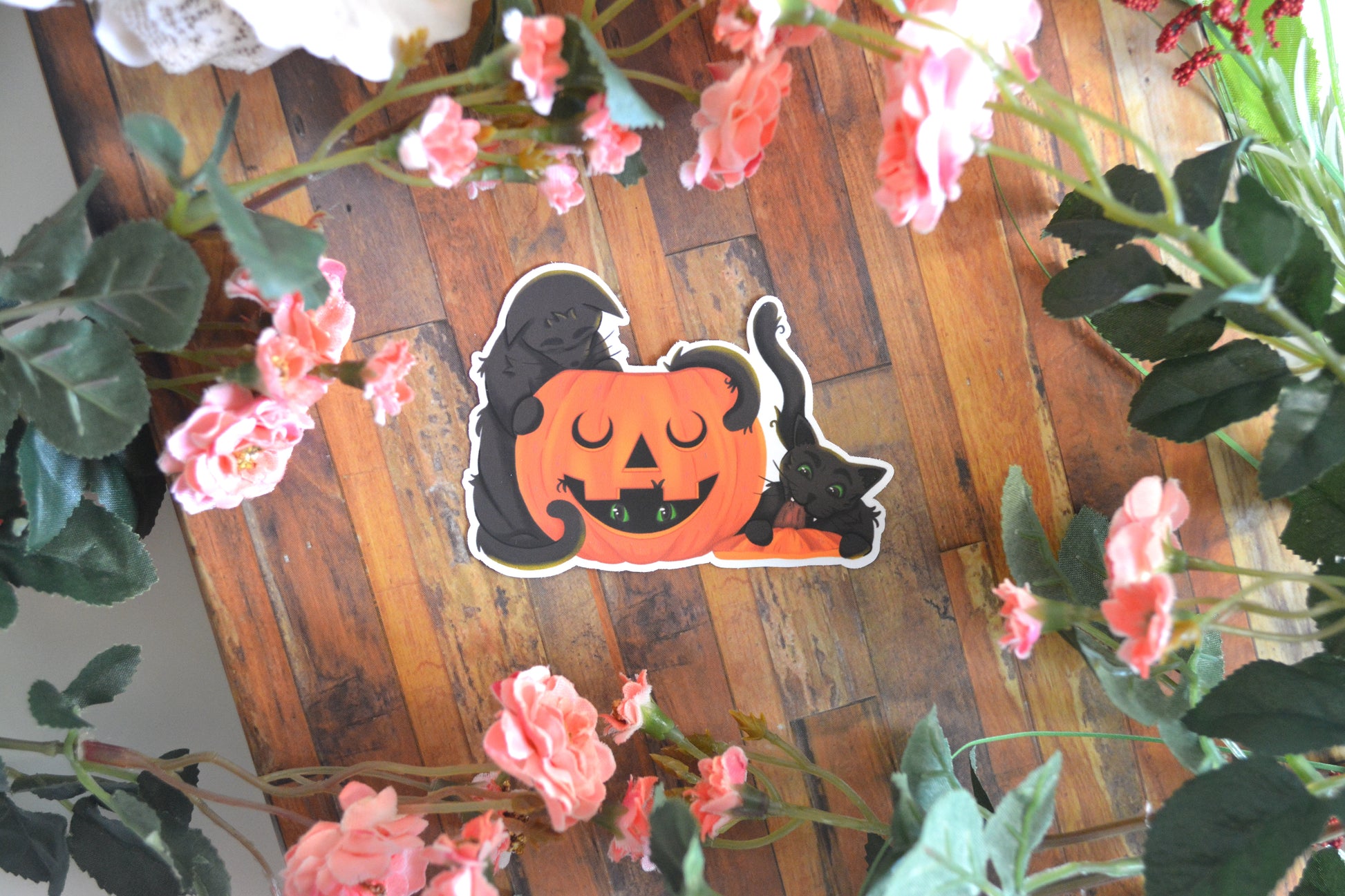 Halloween sticker of playful mischievous cats playing in and around a jack-o-lantern