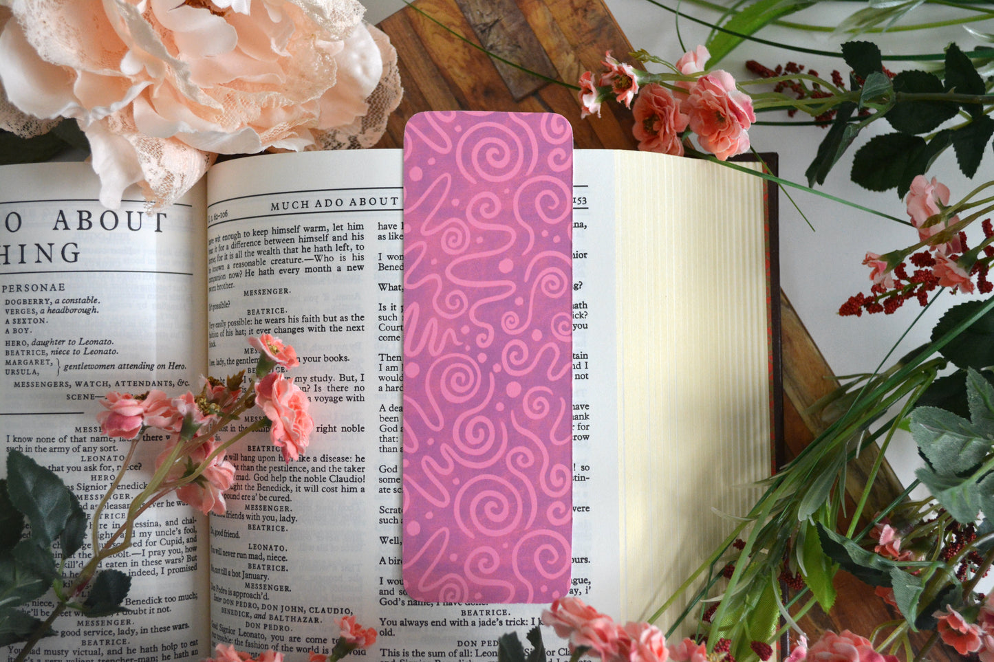 Bookmark with light pink icing drizzle swirls on a purple background.