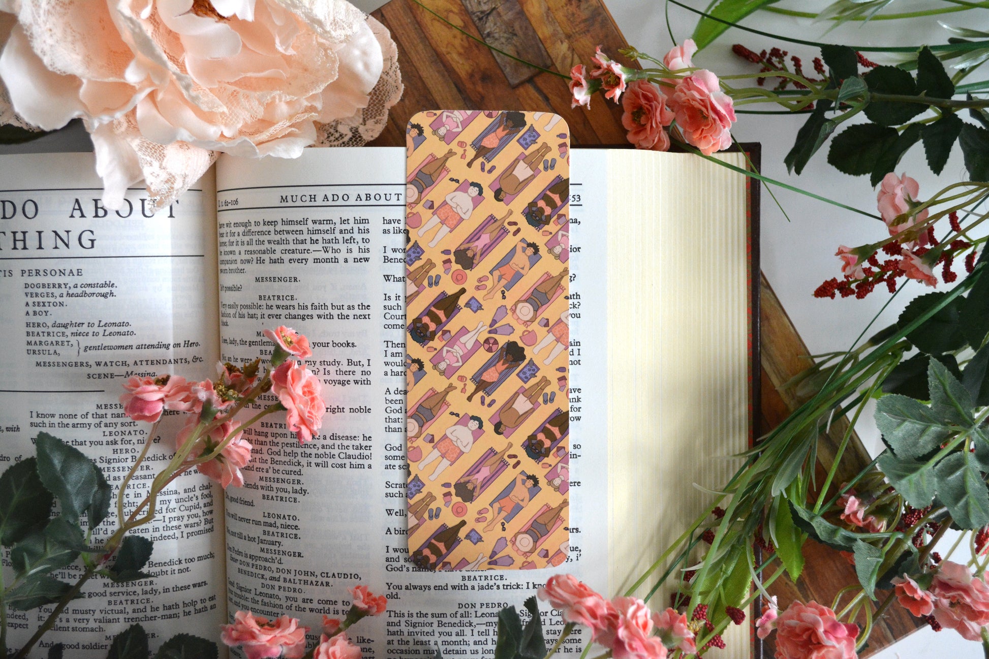 Bookmark with illustrations of diverse characters lounging and suntanning on a yellow sand beach.