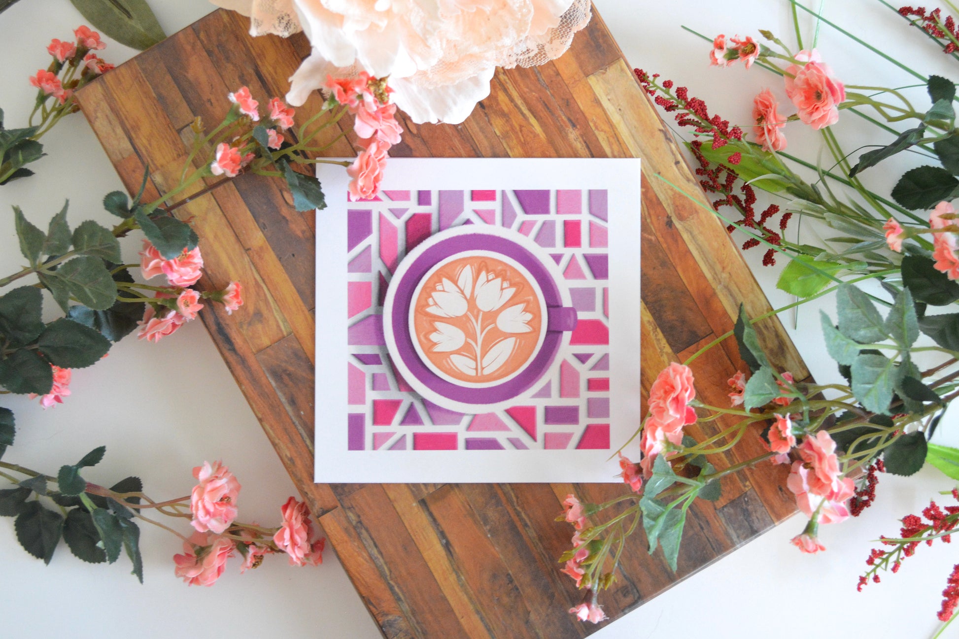 Art print with illustration of tulip latte art in a purple cup, on a purple plate, on a mosaic tile tabletop in shades of pink and purple.